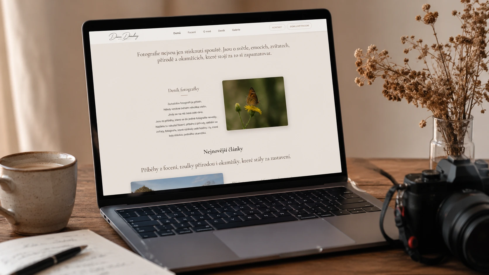 Pracovní stůl fotografky s notebookem zobrazujícím nový fotografický web během jeho tvorby.