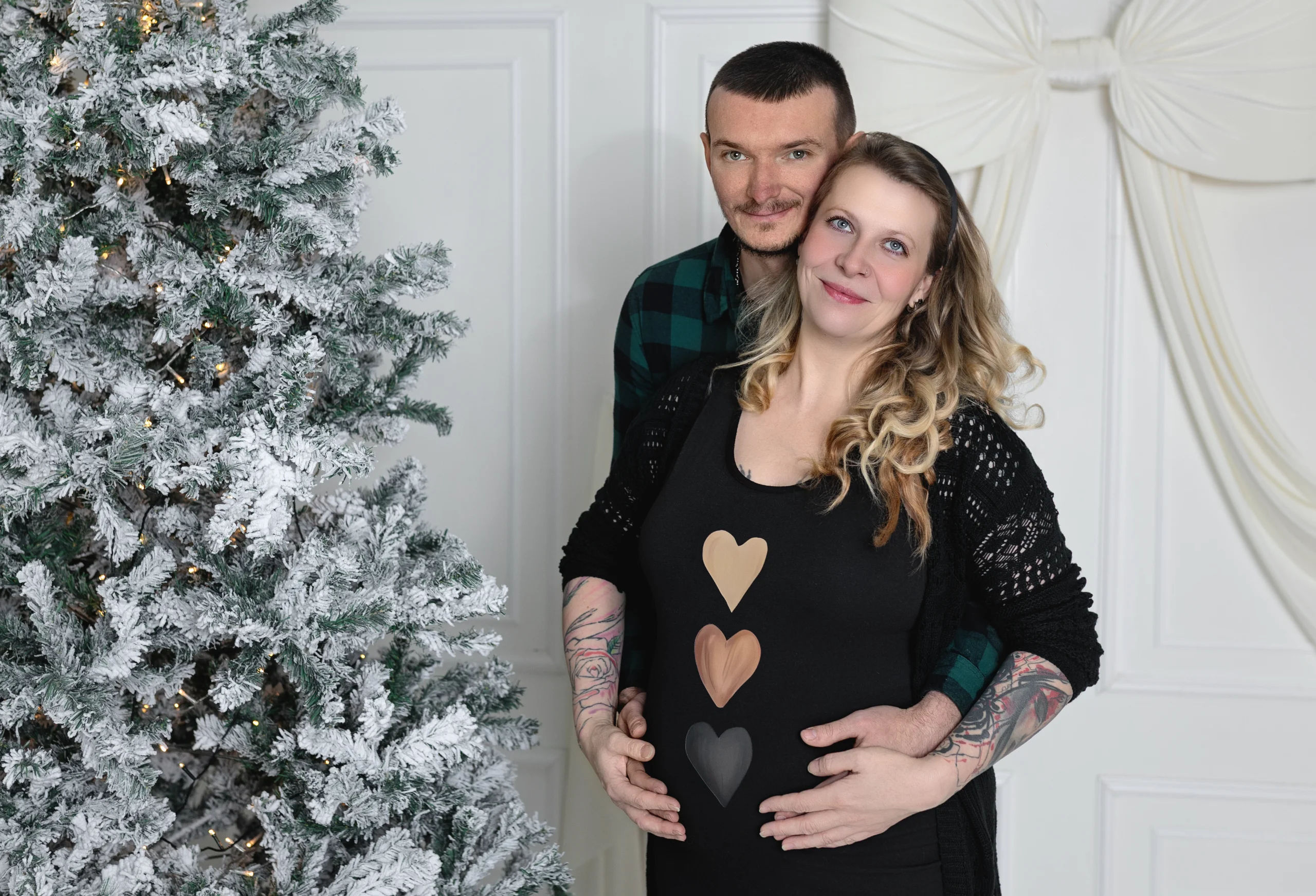 Těhotná žena s partnerem při těhotenském focení v ateliéru.